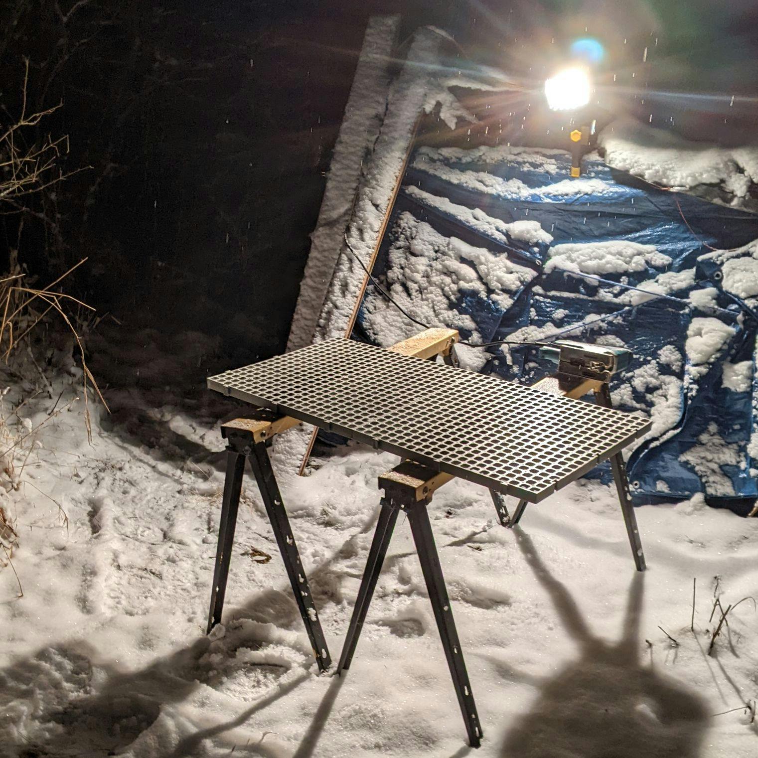Sawhorses in the snow but its 1am and I'm cutting flooring because I have no sleep schedule
