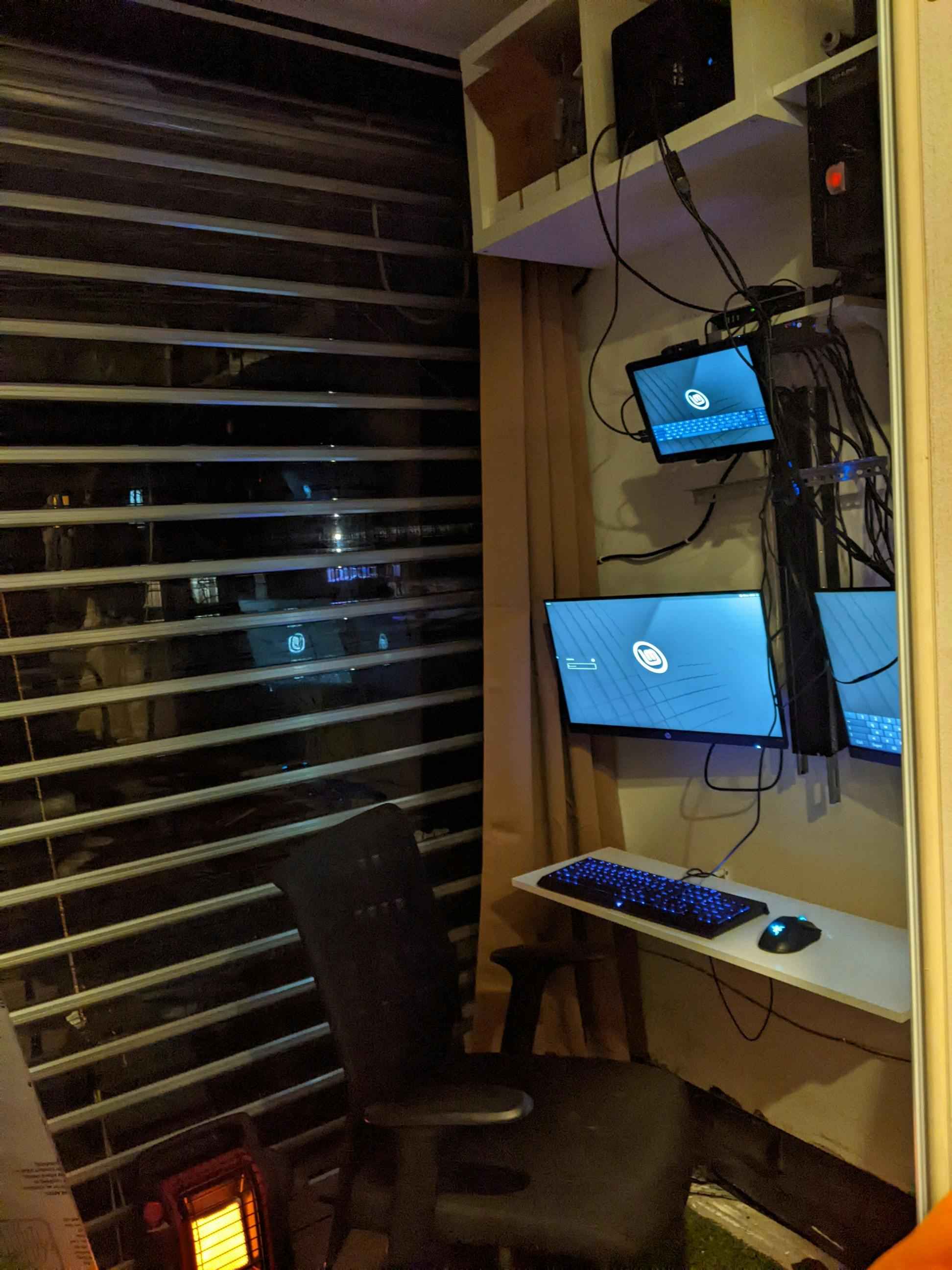 My computer setup inside the tiny home behind the roller door, with my computers, network rack, and tablet
